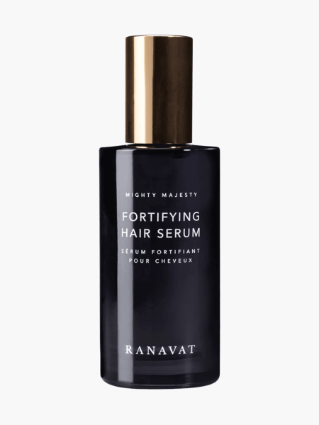 Fortifying Hair Serum in branded black bottle with soft gold cap on light gray background